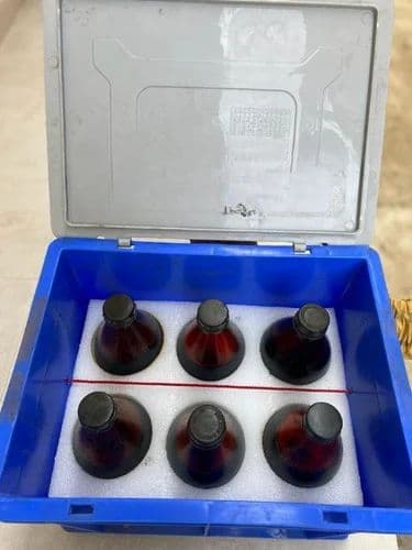 Open crate showing bottled liquid bromine packed for transport